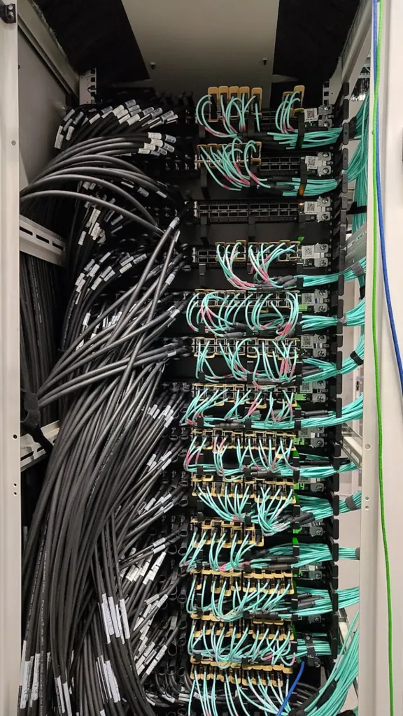 Dense InfiniBand and fibre cabling inside a GPU cluster network rack